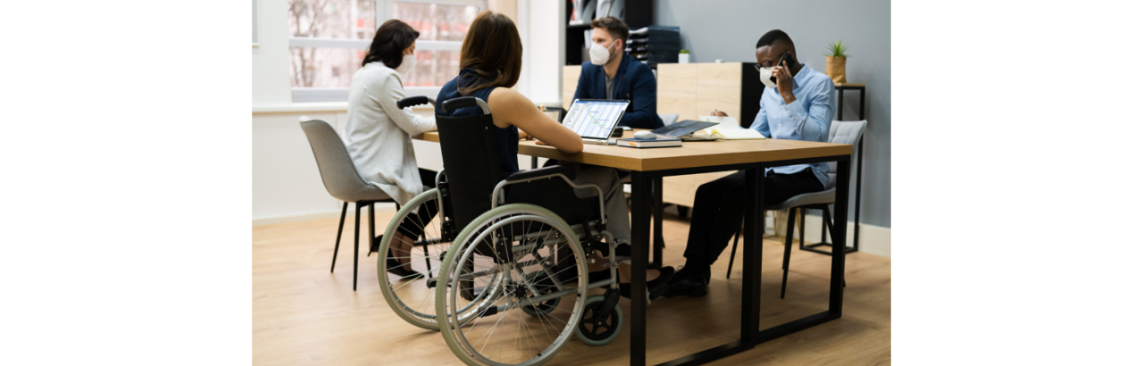 people around a table, one with a wheelchair